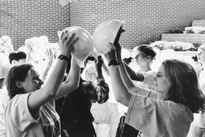 Engineering Studnets touching helmets to each other