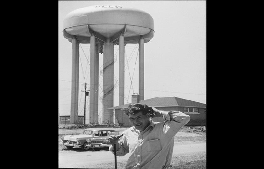Student pictured with water tower behind him.