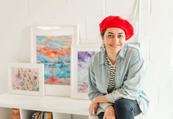 Photos of Parisa Golchoubian (MASc '17) with a white brick background and several pieces of art.