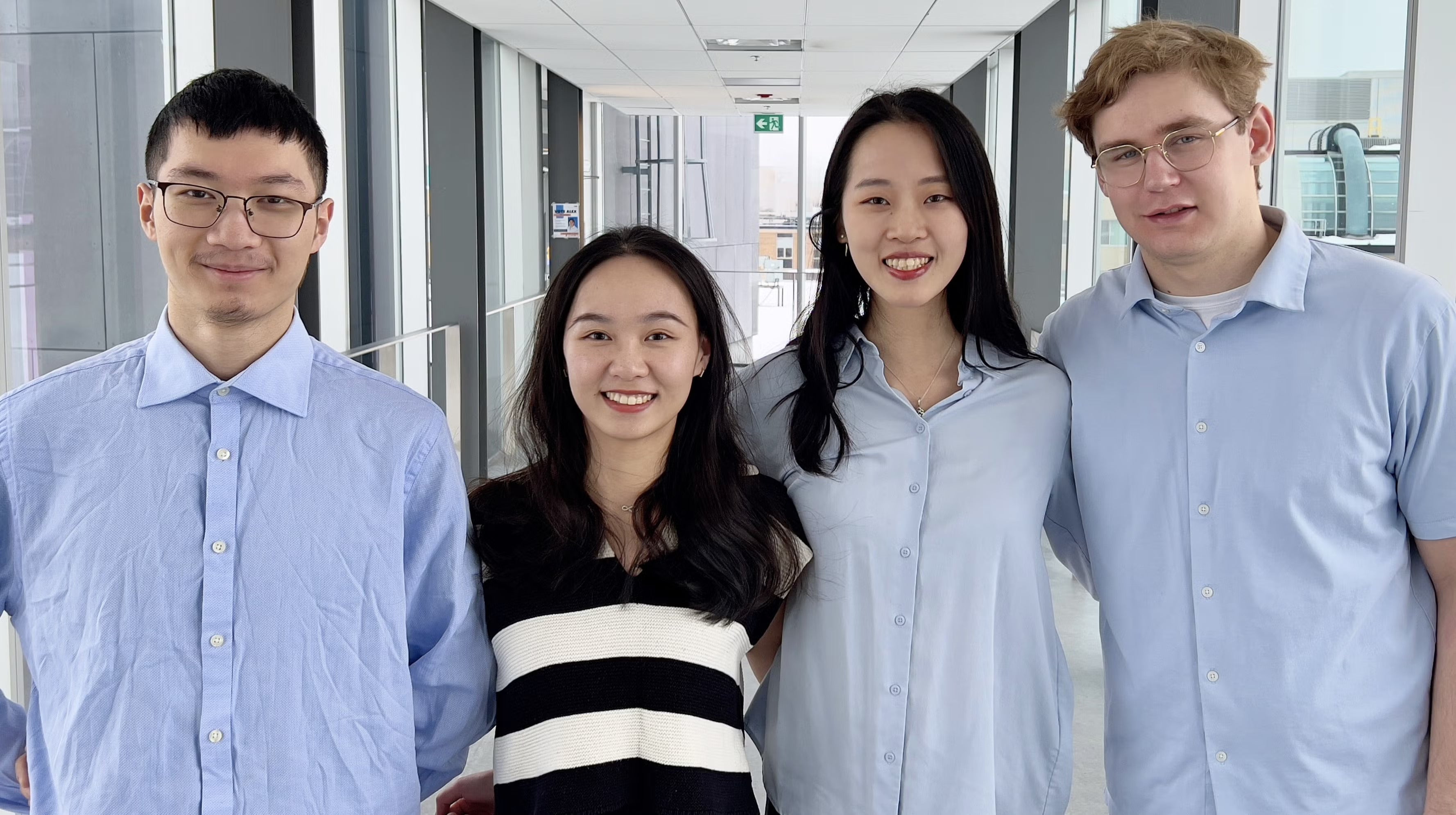 Group of four students smiling at camera