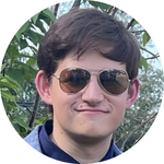A young man with sunglasses smiles at the camera