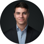 A young man wearing a suit smiles at the camera