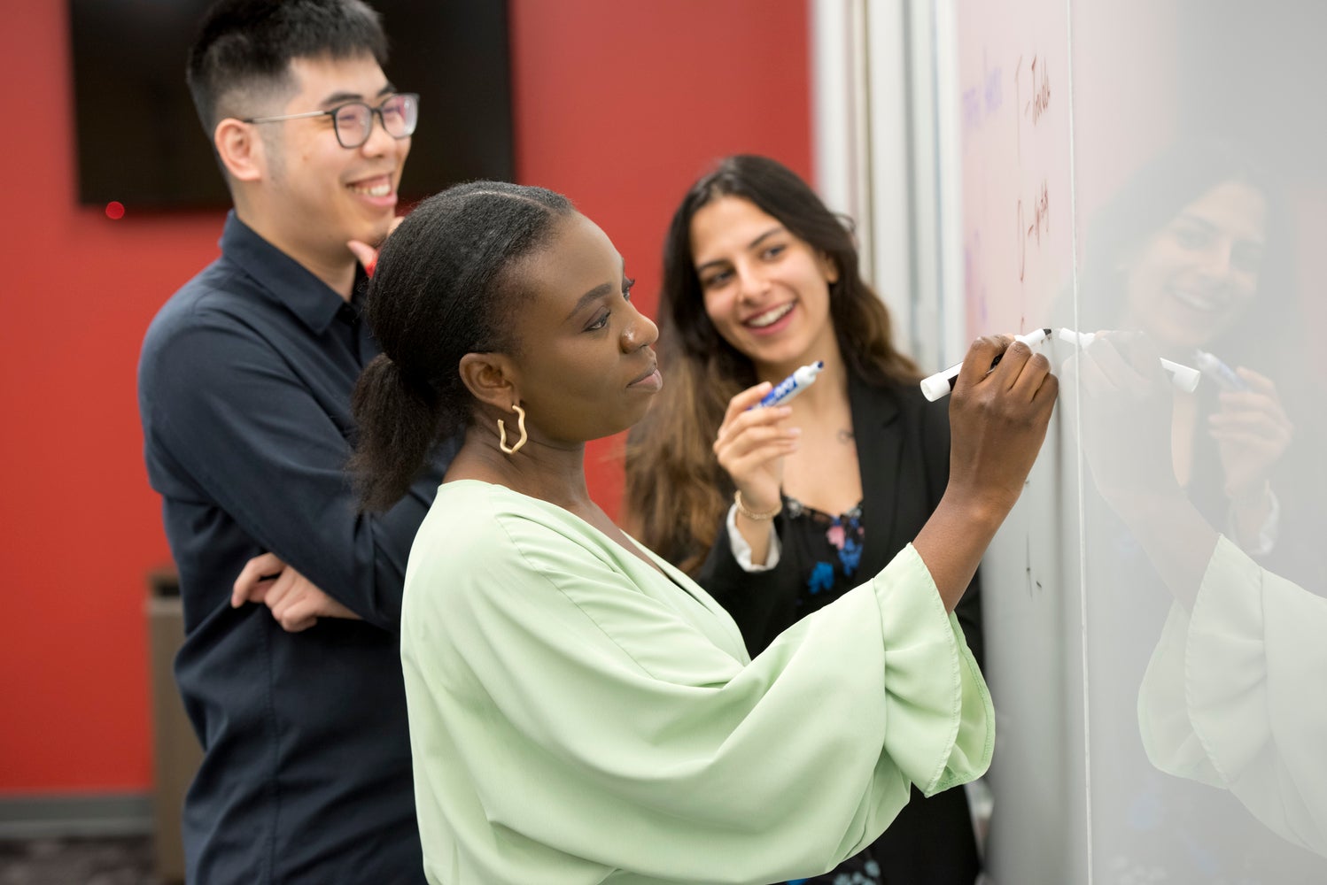 Group of students writing on a whiteboard