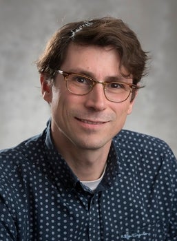 White man smiles at the camera