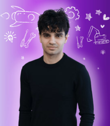 A young man smiles at the camera