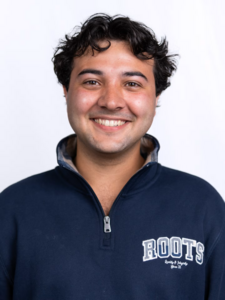 A young man smiles at the camera.