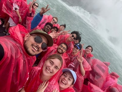A group of young people in rain gear on a boat in Niagara Falls.