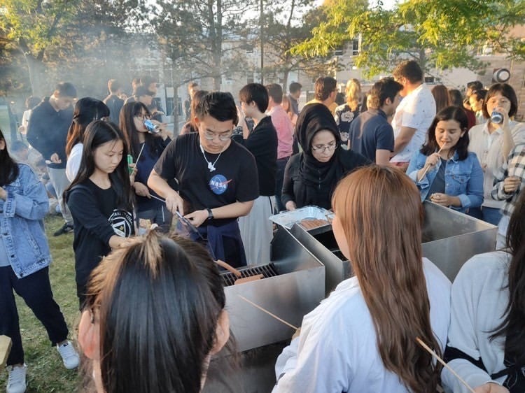 iBASE Peer Leaders Bruce and Reham were busy serving food at the Bonfire Party (a photo by Tim).