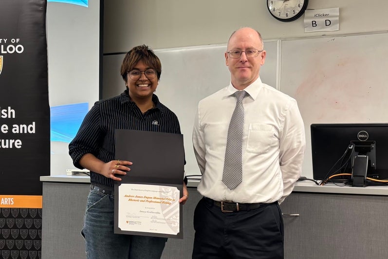 Dr. George Lamont presents Amaya Kodituwakku with the Andrew James Dugan Prize in Rhetoric and Professional Writing.