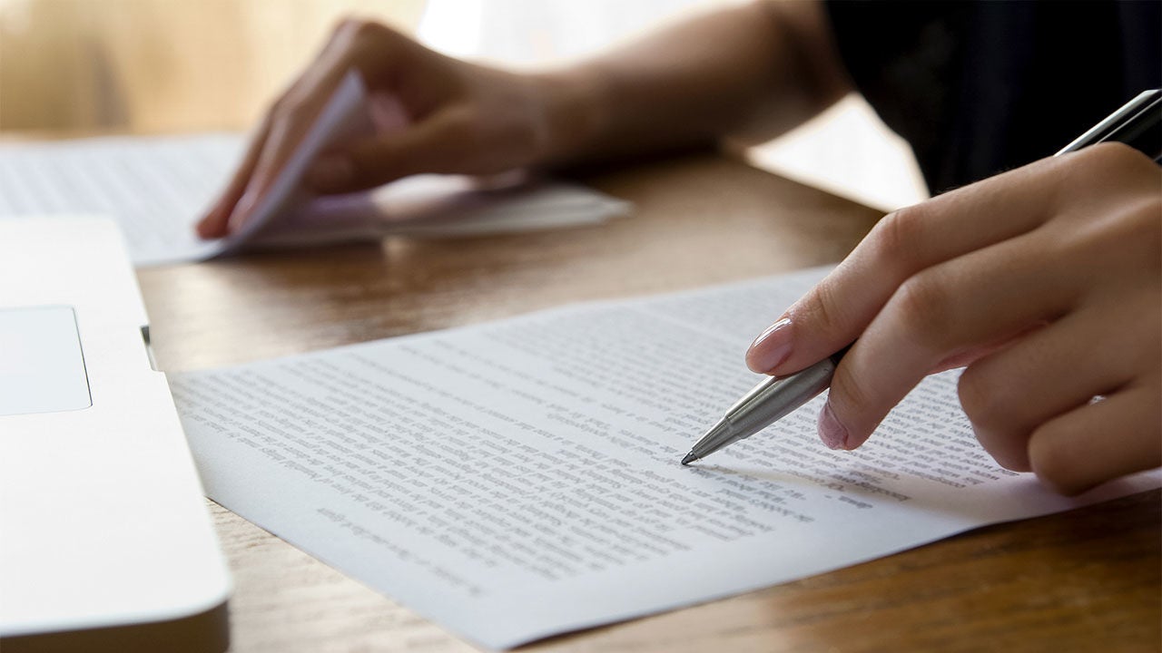 Photo of person writing on a paper.