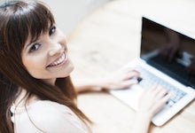 Photo of smiling woman at computer.