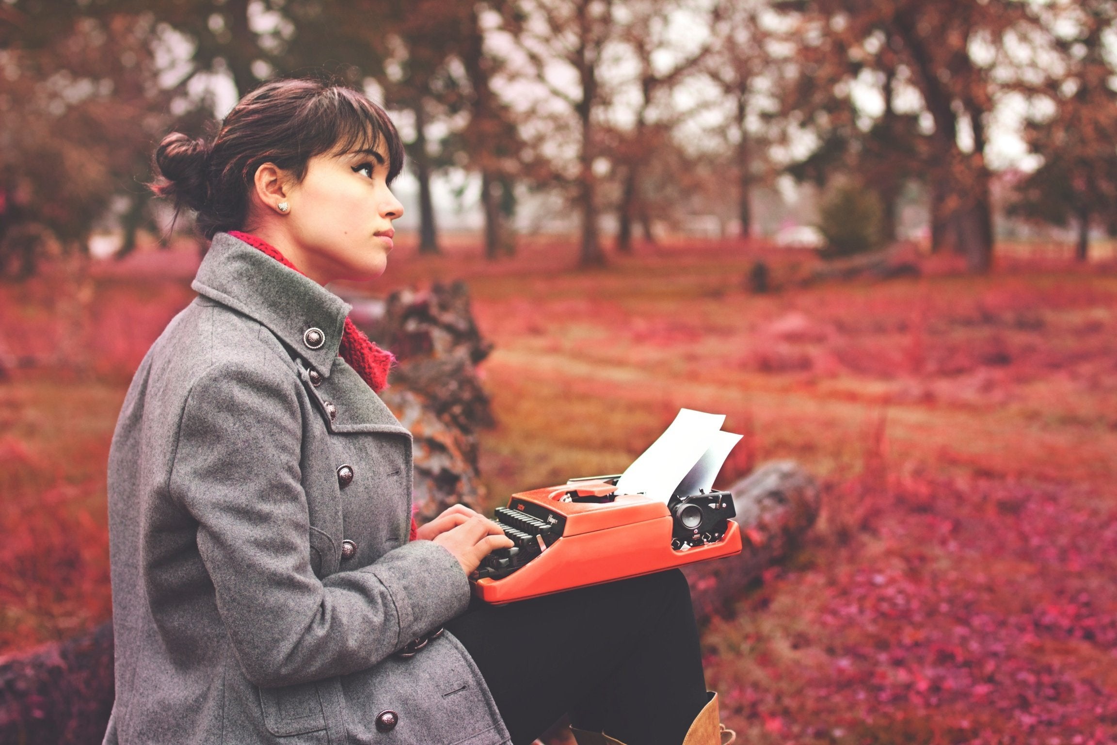 Photo of woman with typewriter in woods.