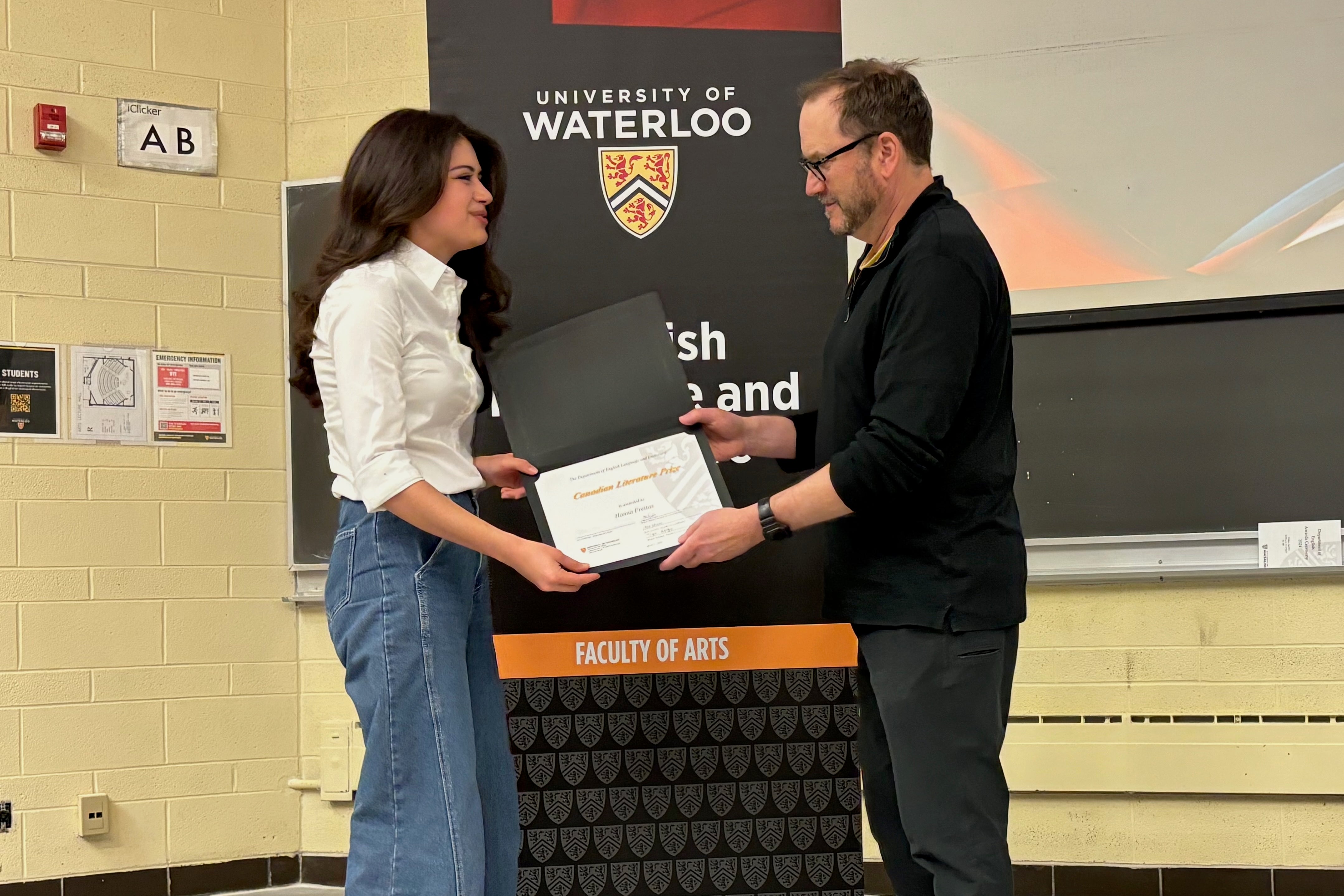 Hanna Freitas receives the Canadian Literature Prize from Andrew McMurray.