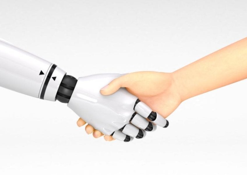 Photo of robot hand shaking human hand.