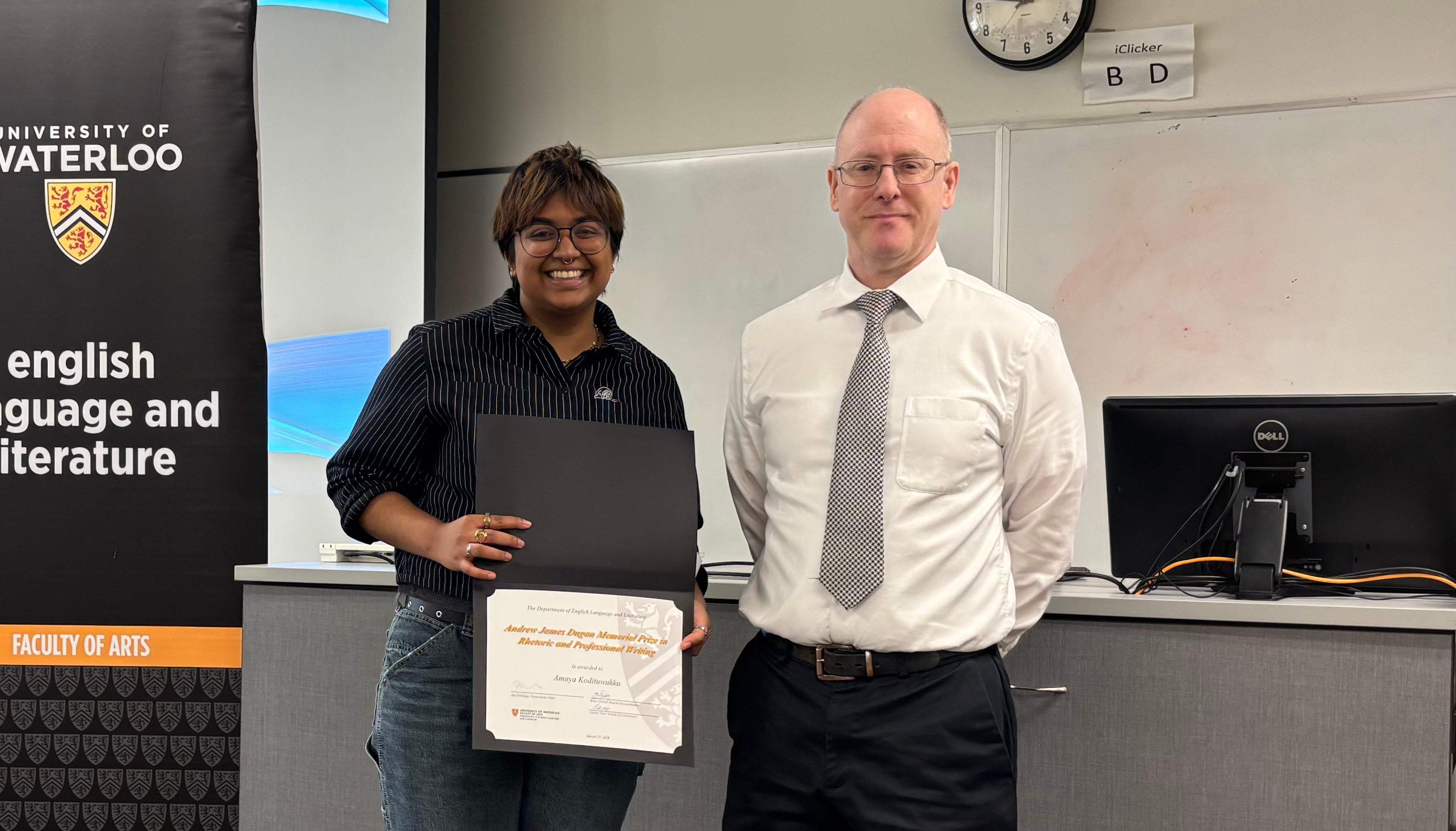 Dr. George Lamont presents Amaya Kodituwakku with the Andrew James Dugan Prize in Rhetoric and Professional Writing.