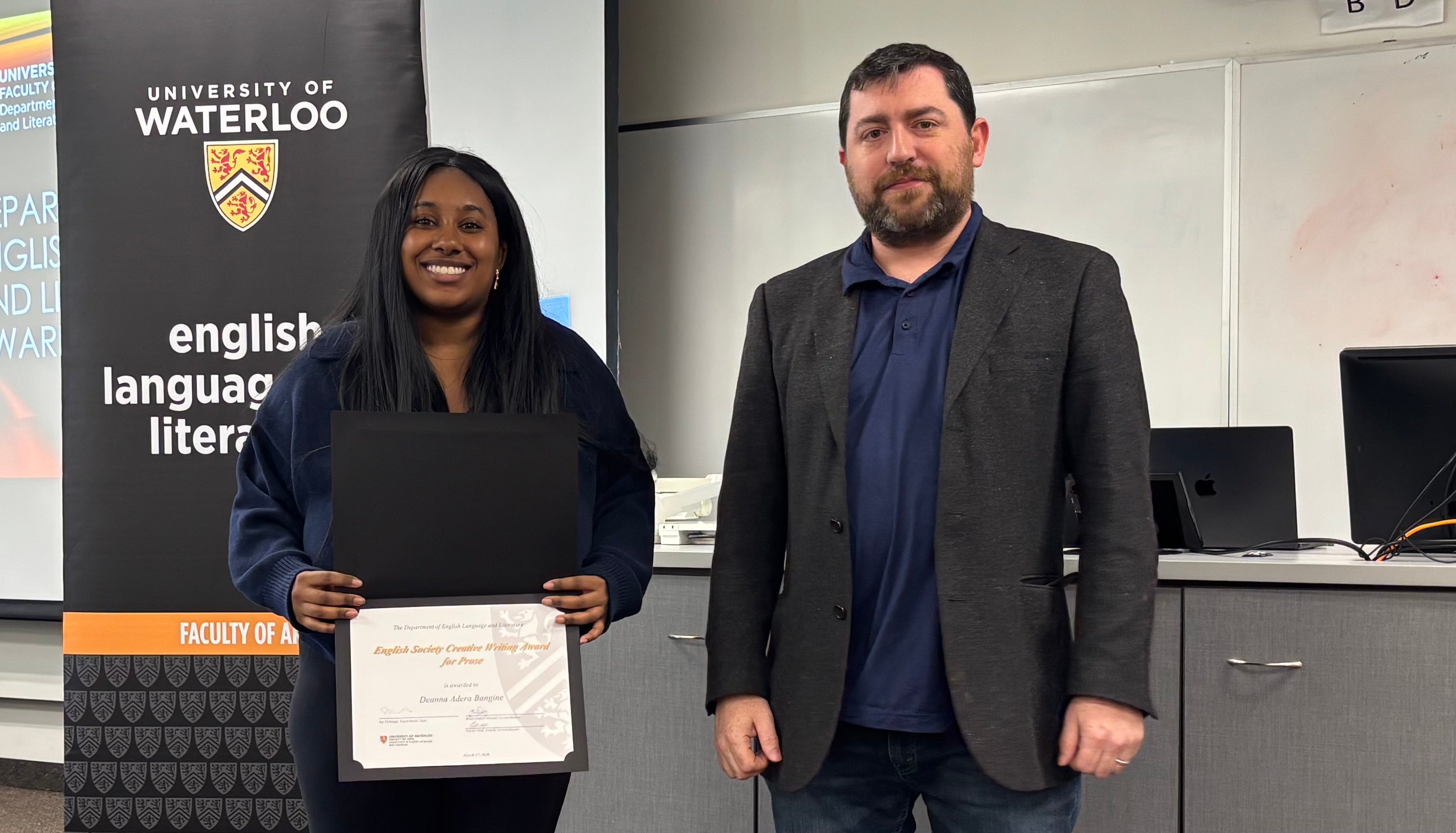 Dr. John Savarese presents Deanna Adera Bangine with the English Society Creative Writing Award for Prose .