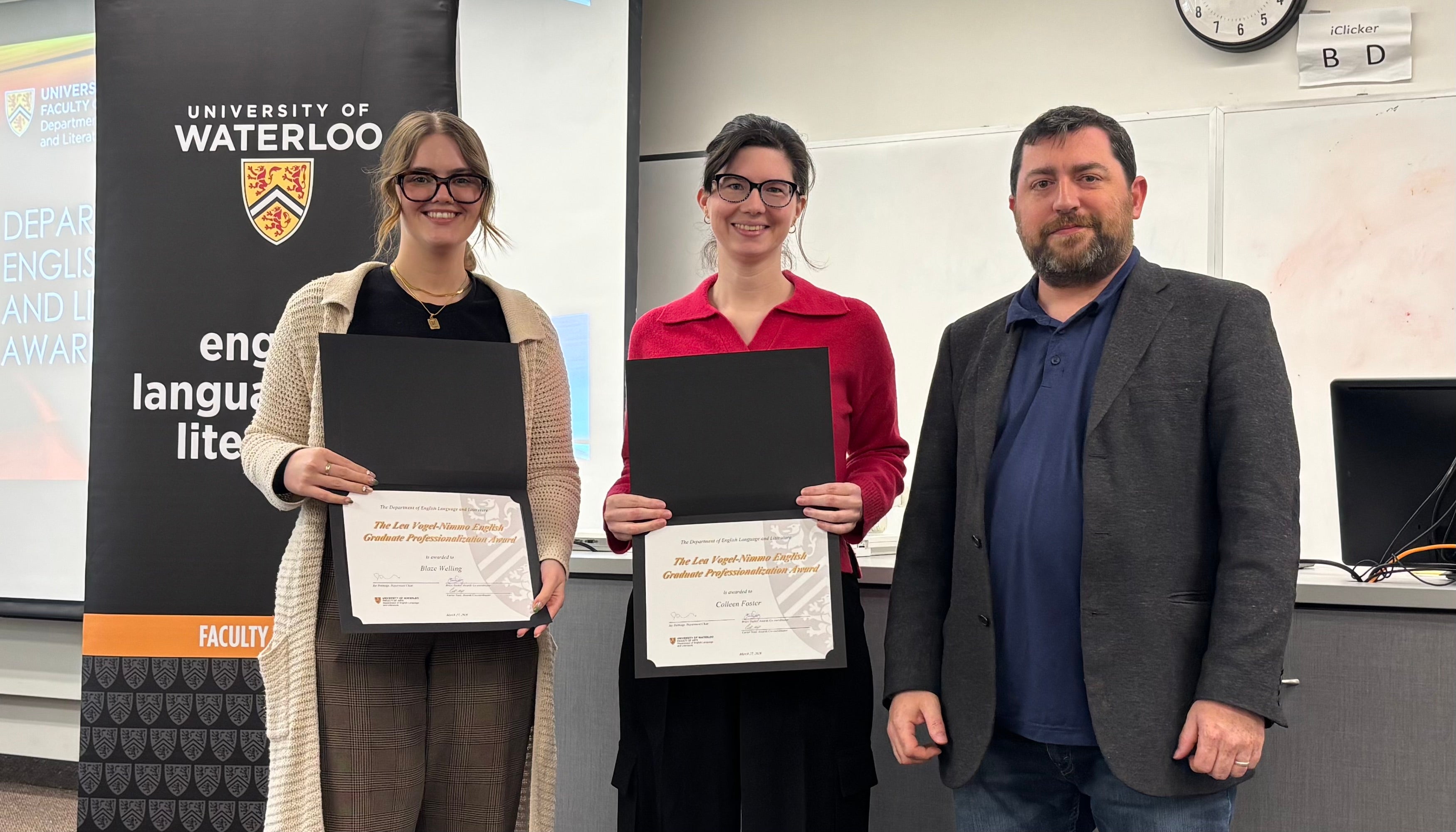 Dr. John Savarese presents Blaze Welling and Colleen Foster with the Lea Vogel-Nimmo English Graduate Professionalization Award.