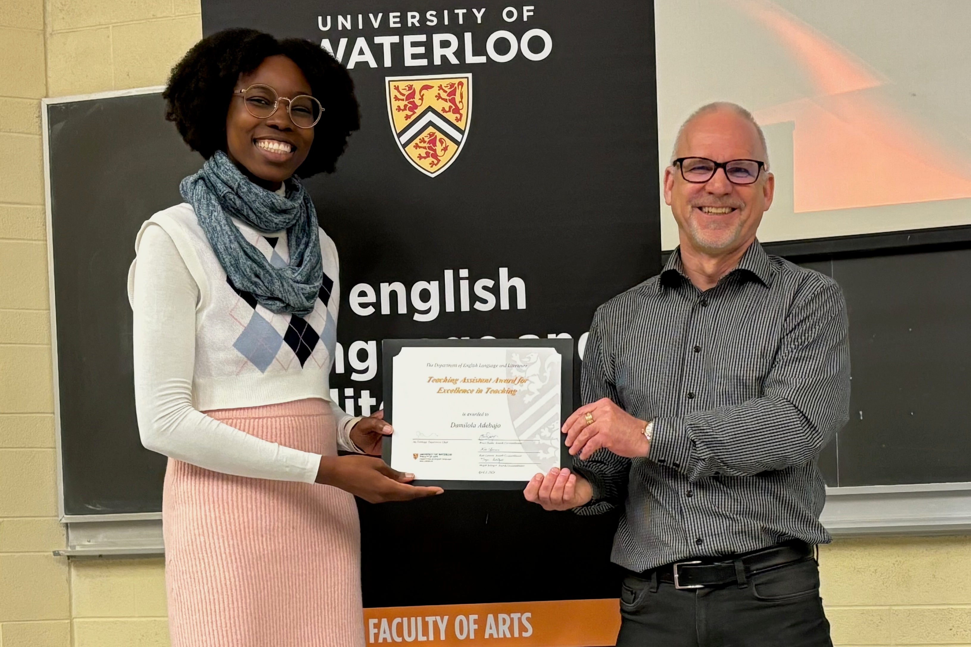 Damilola Adebajo receives the TA Award for Excellence in Teaching from Dr. Bruce Dadey.