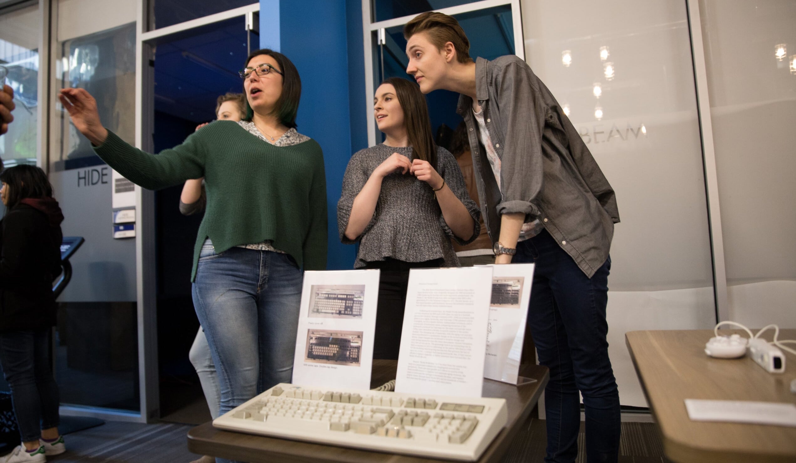 Photo of three students in front of a display about computers.