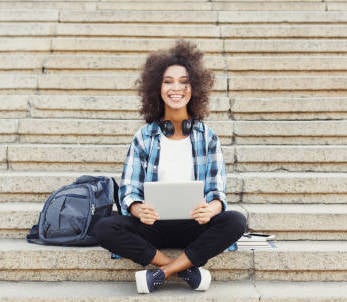 Photo of woman with laptop on stairs.