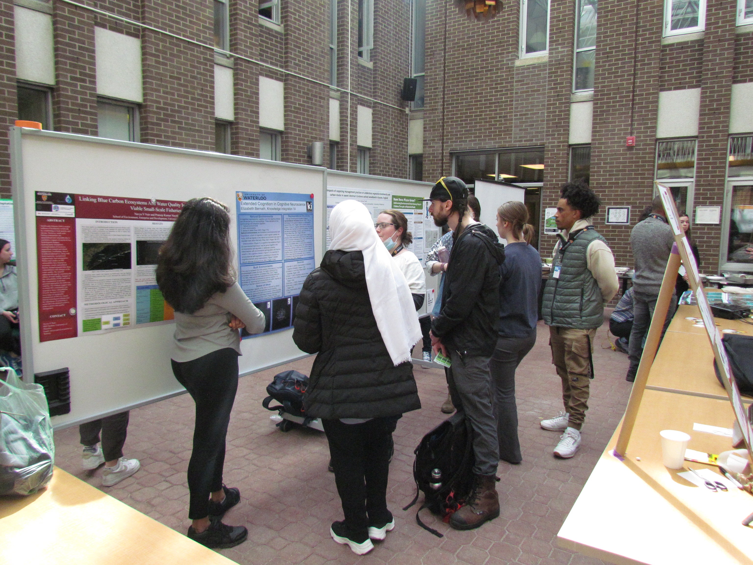 Students reading presentation board at the Student Showcase.