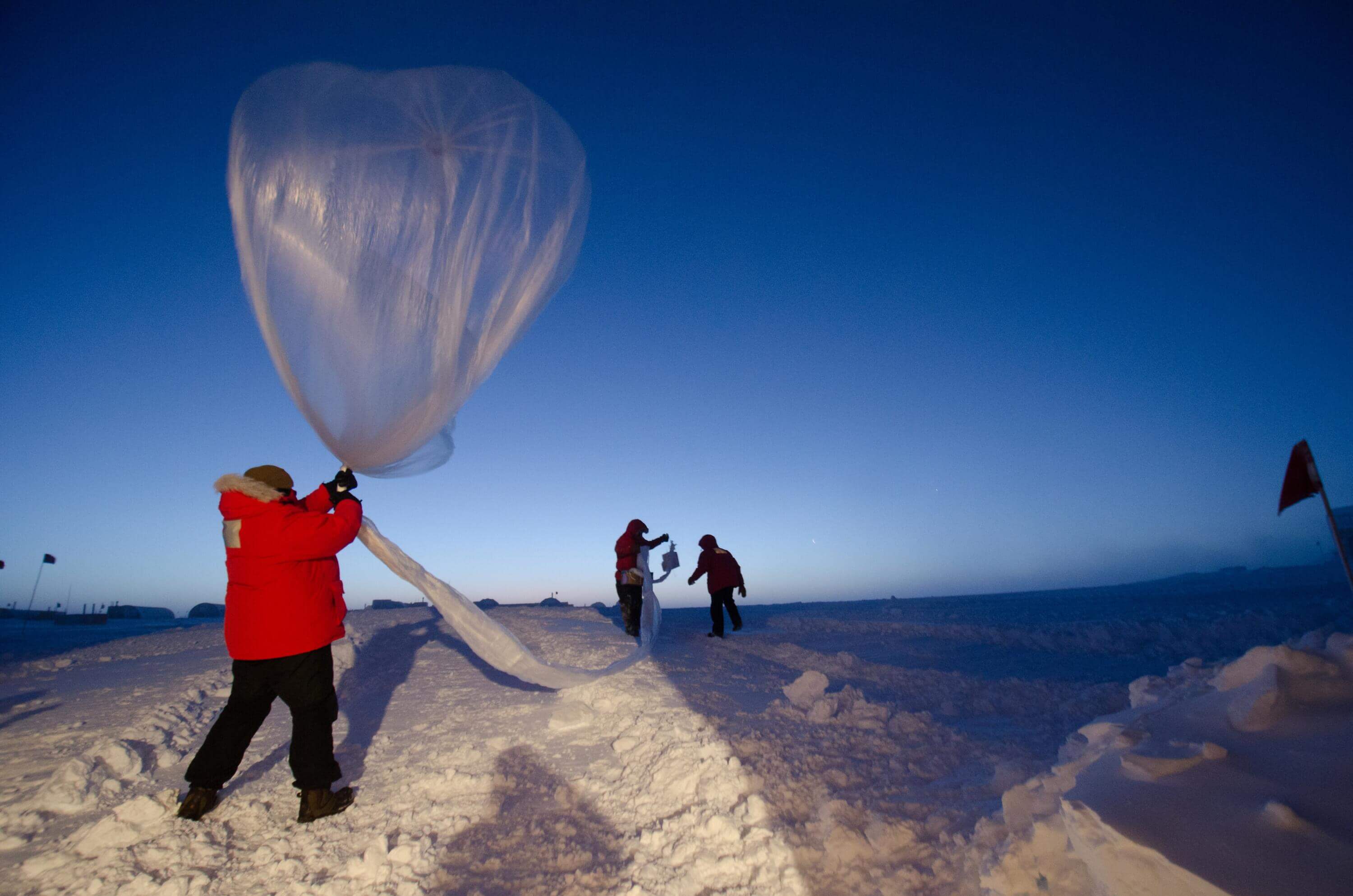 A man with a parka and a weather balloon