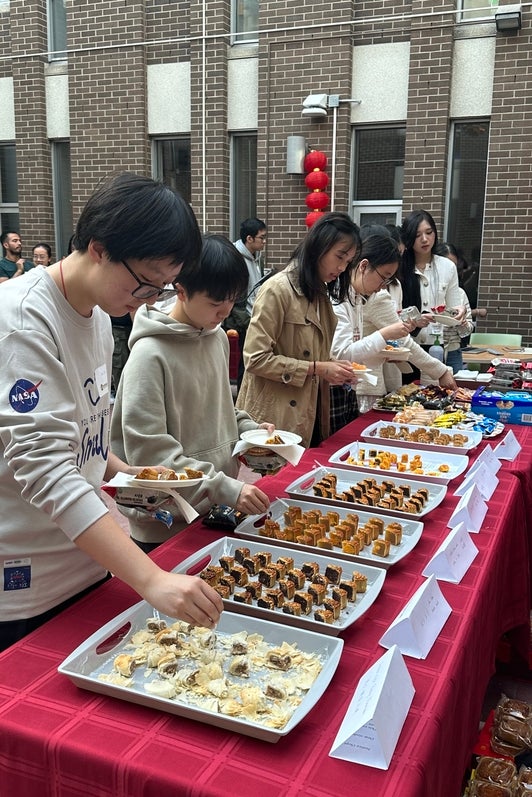 Attendees grabbing moon cakes and other snacks