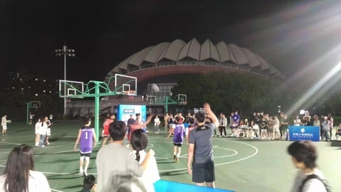 people playing 3 on 3 basketball in the evening