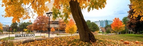 University of Waterloo sign visible in the Arts quad with trees and leaves in fall colours
