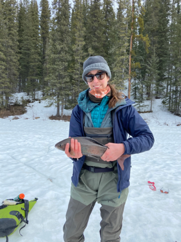 Jess Kidd, outside during winter, holding a fish