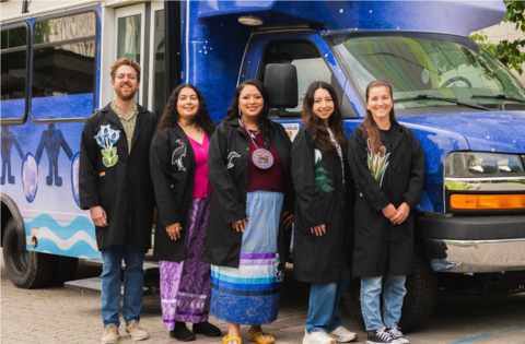 Kelsey Leonard and team stands beside the WAMPUM lab mini-bus which is brightly painted with Indigenous artwork