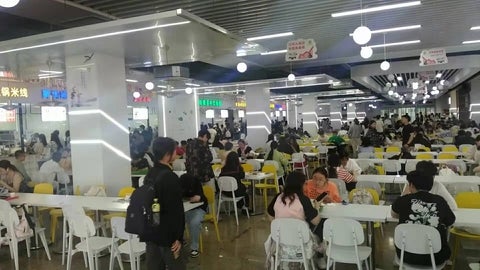 students in a cafeteria at NUFE