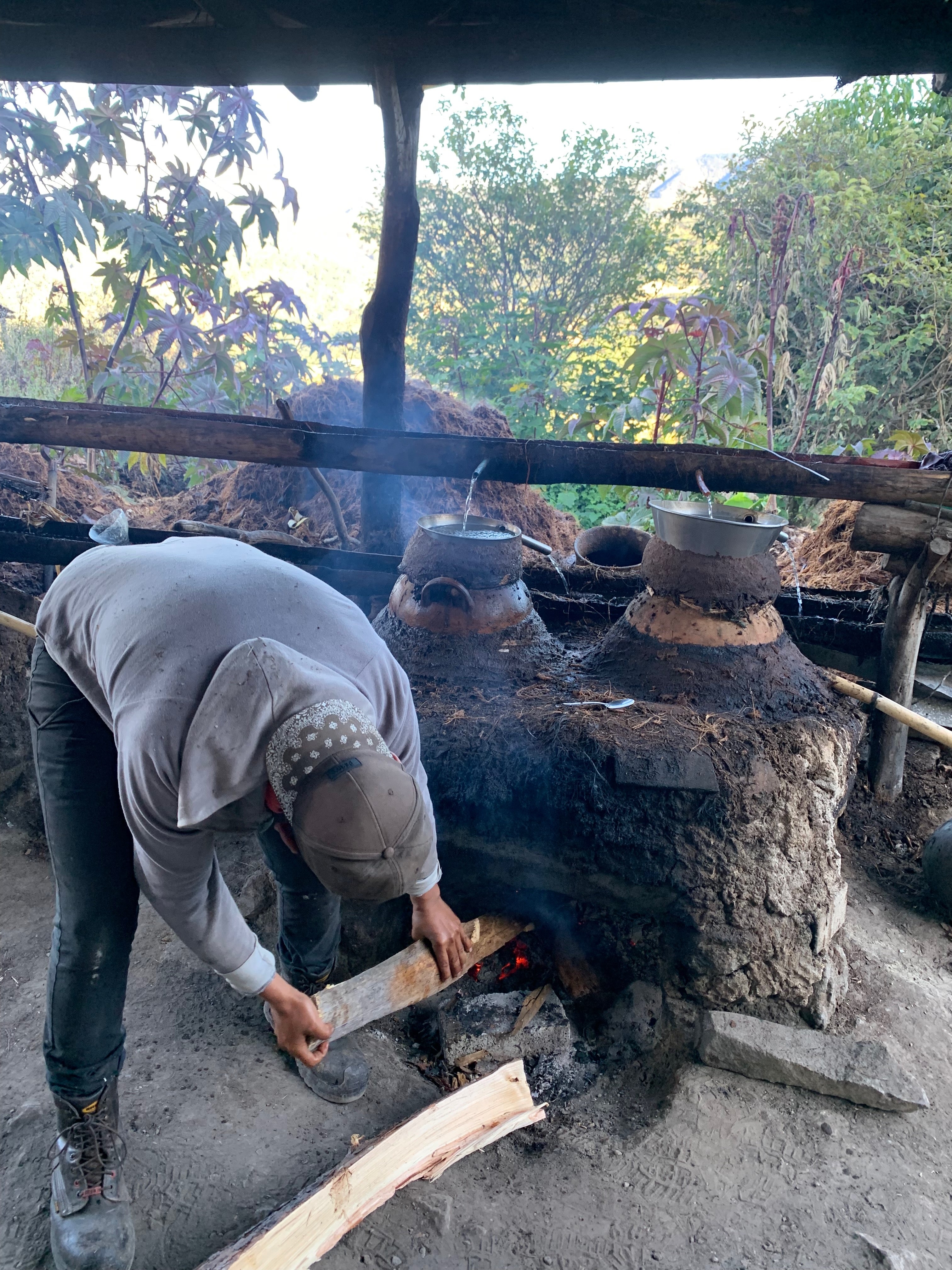a man loads firewood into a mudpack still in a outdoor area 