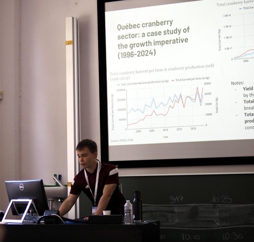 Henri Chevalier delivering a conferenc presentation showing a slide related to the Quebec cranberry sector
