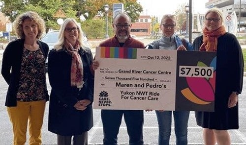 Maren Oelbermann and Pedro Gonzalez Hernandez hold a cheque to the Grand River Cancer Centre for $7500 marking funds raised by the ride, giving to staff at the centre.