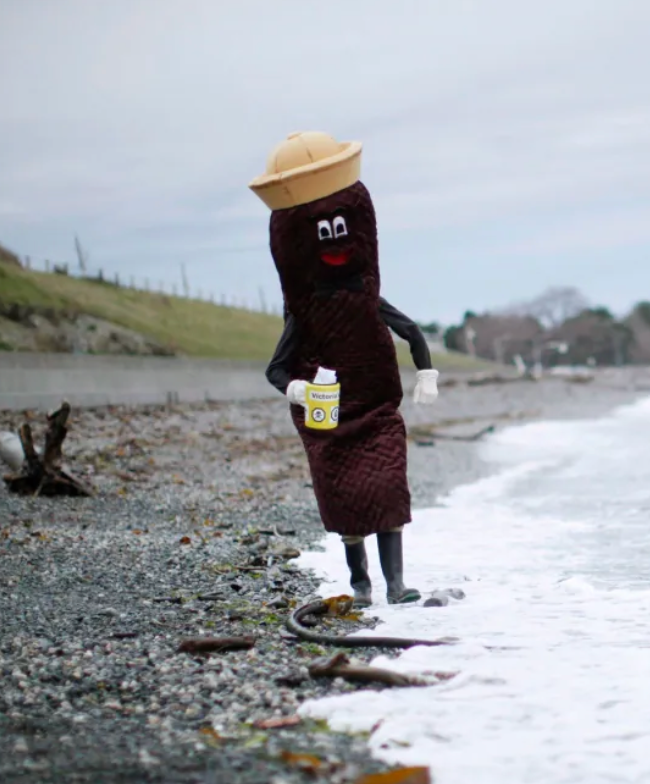 Mr. Floatie mascot character walking along a beach.