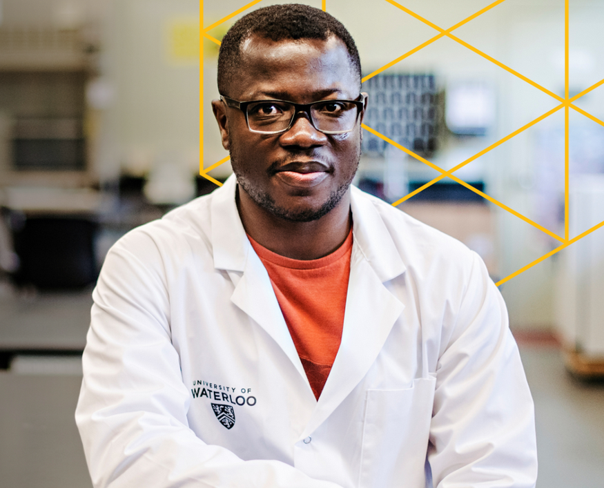 Augustine Osei wearing a white lab coat, sitting in a lab.