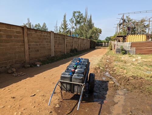 A water supply hand cart in East Africa with 10 water containers on it