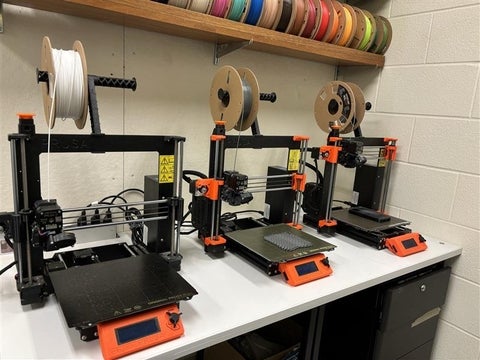 Three 3D printers in a line.