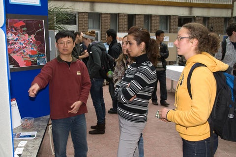 Steve Xu presenting his poster to a small group of students.