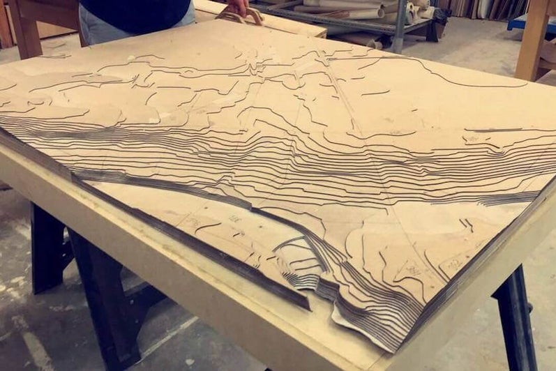 Terrain model made with laser cutter using contour lines and layering the cutouts on top of each other.