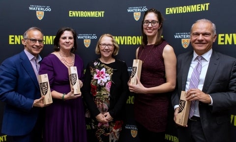 Group of indivudals holding awards