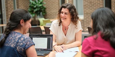 Two students talking to a faculty member