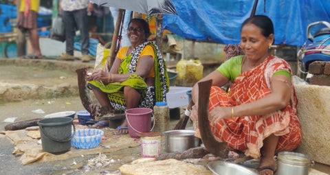 Women laughing and sitting on the streets of Chilika, India