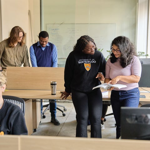 Graduate students in groups discussing projects