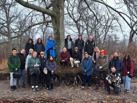 Class of students beside a tree. 