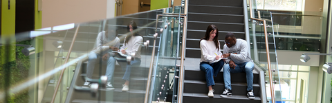Two students sitting on the stairs