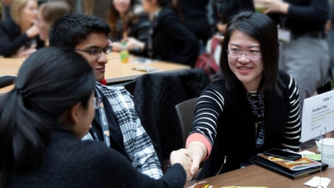 Two students shaking hands.