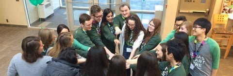 Students putting hands in a circle