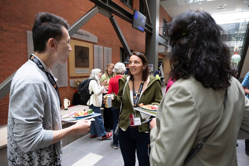 Three people in conversation at a reception.